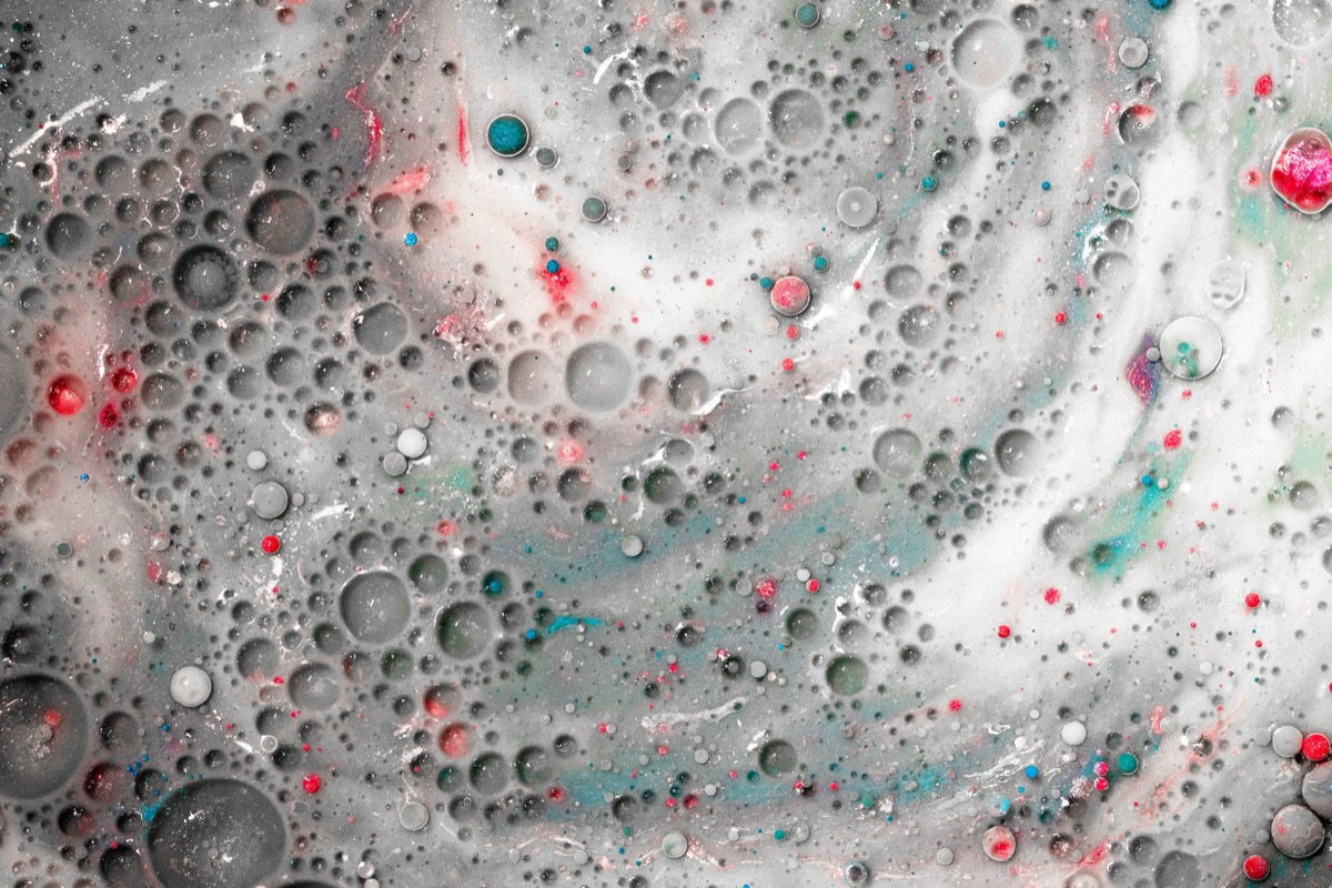 Close-up of a ceiling with a large section of paint bubbling and peeling, indicating moisture damage.